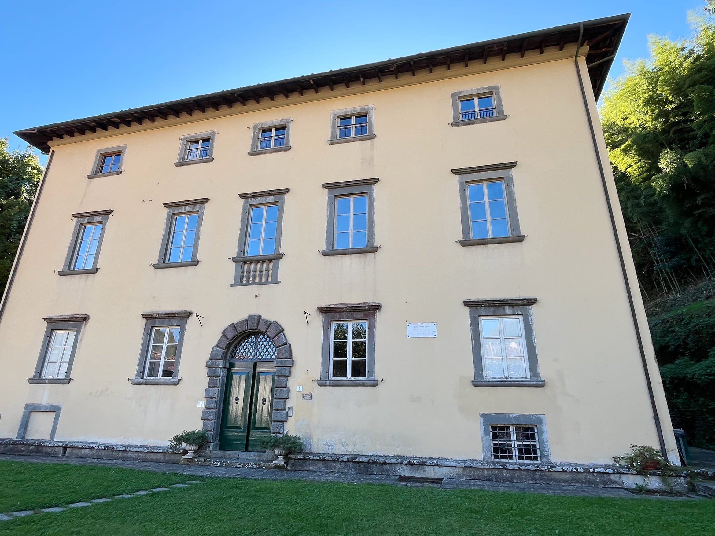 Large three-storey villa, cream coloured, green doors