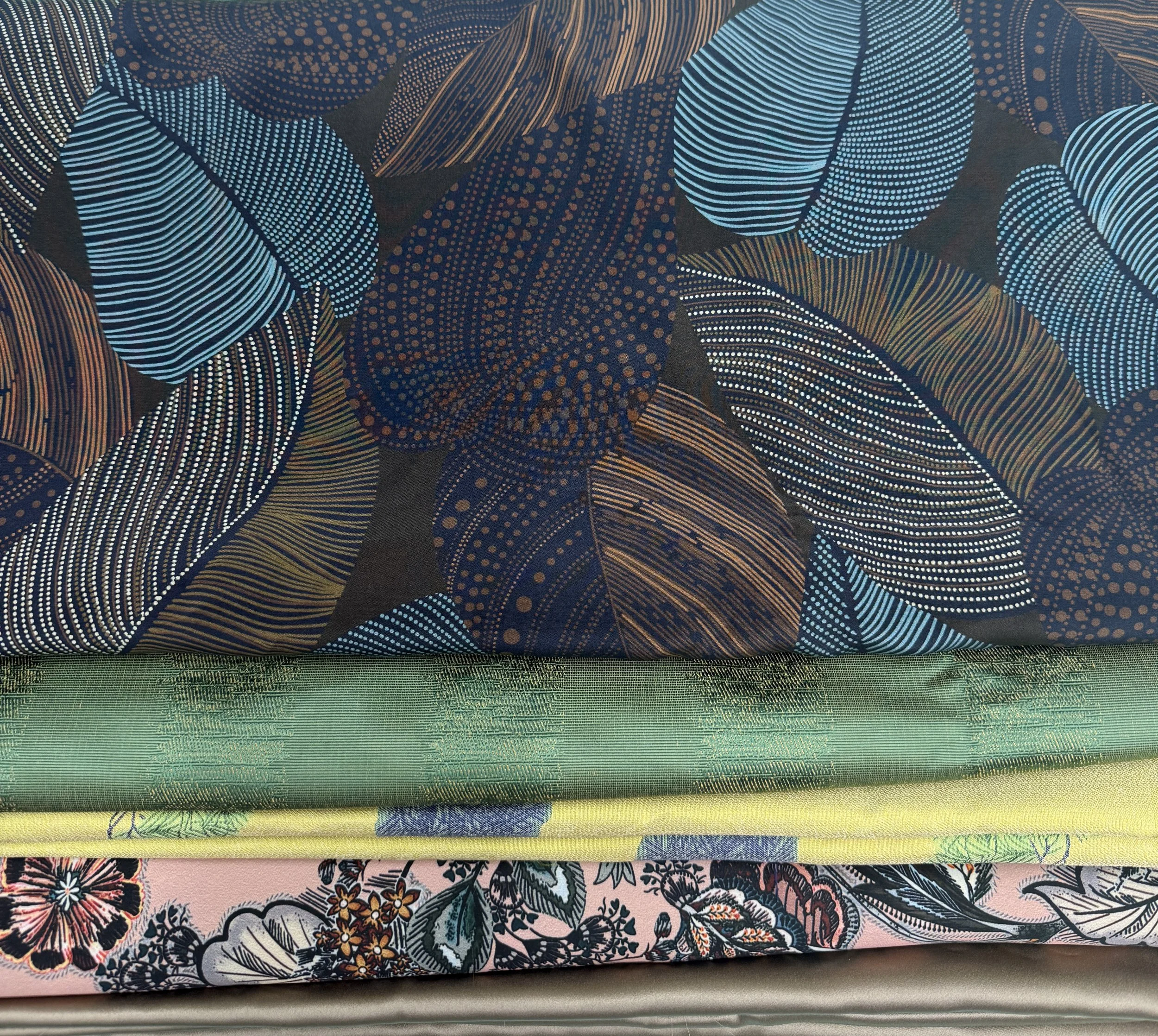 Colorful patterned and textured fabrics stacked in the Kaya Berlin NYC design studio.