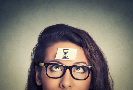 47505593 - time management concept young woman with sand clock sign sticker on her forehead