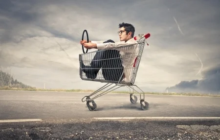 22776331 - businessman into a cart pretending to drive a car
