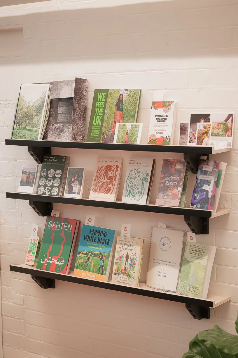 Books arranged on shelves, with themes of land, growing and racial justice.