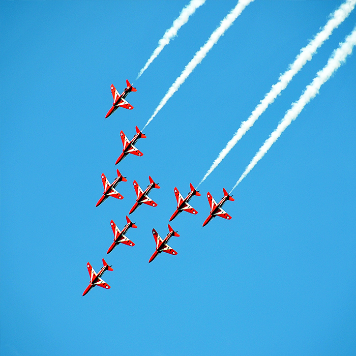Red Planes in Blue Sky Performing Air Show