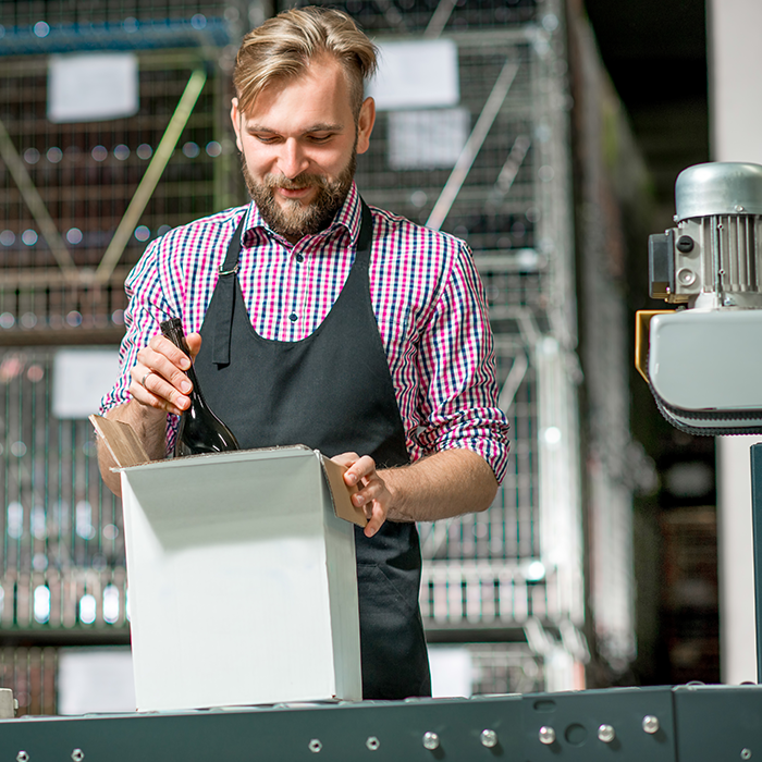 man packing white cardboard box in case sealing machine