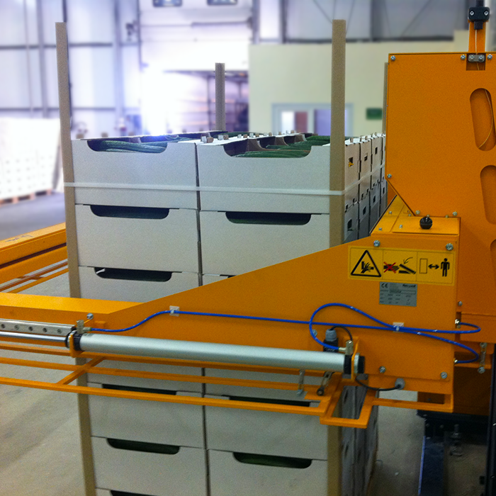 pallet of english cucumbers being secured by automatic strapping machine