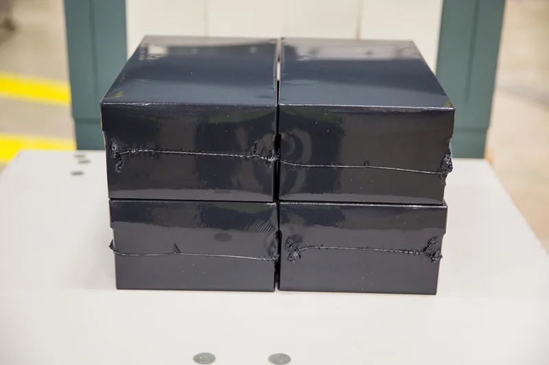 stack of four packaged wrapped in sealed air stealthwrap inside packing facility