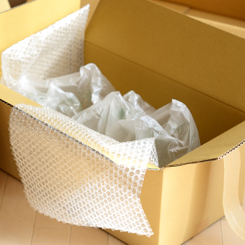 sheets of inflated bubble wrap inside cardboard box on the floor