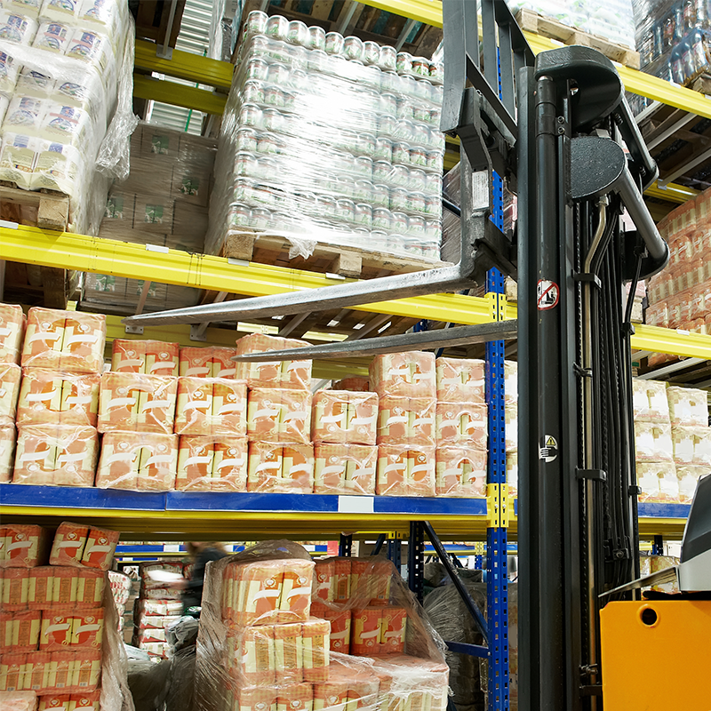 forklift in front of warehouse shelf filled with food products