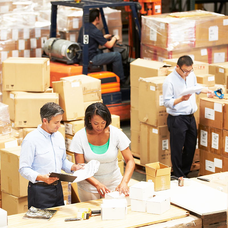 people working in warehouse surrounded by boxes in ecommerce fulfillment facility