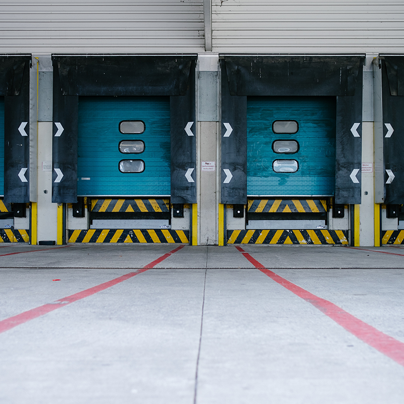 closed blue shipping loading docks with empty parking lot