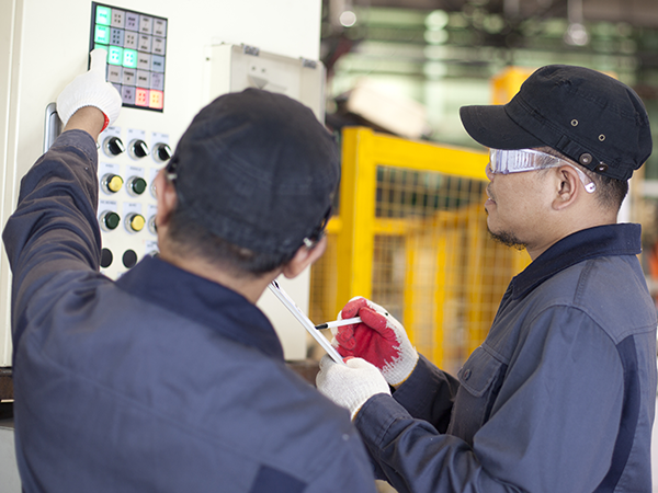 two service technicians standing next to packaging machine training operators