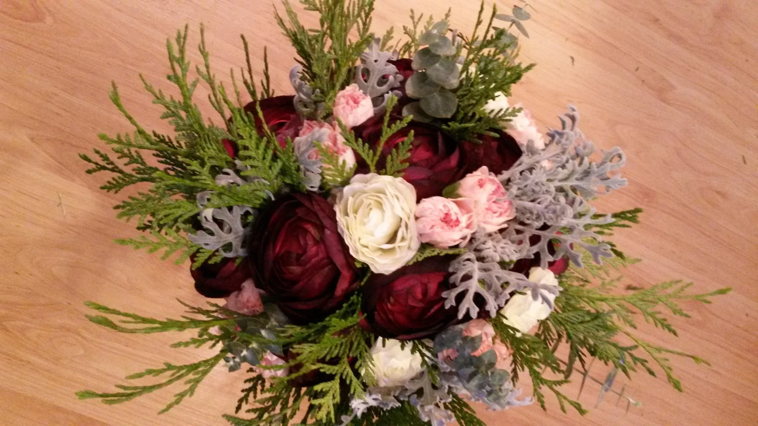 An elegant Bridal Bouquet for the lovely Kate. Burgundy and Cream Ranunculus, Fresh Cedar and Eucalyptus, Dusty Miller and Pink Carnations.