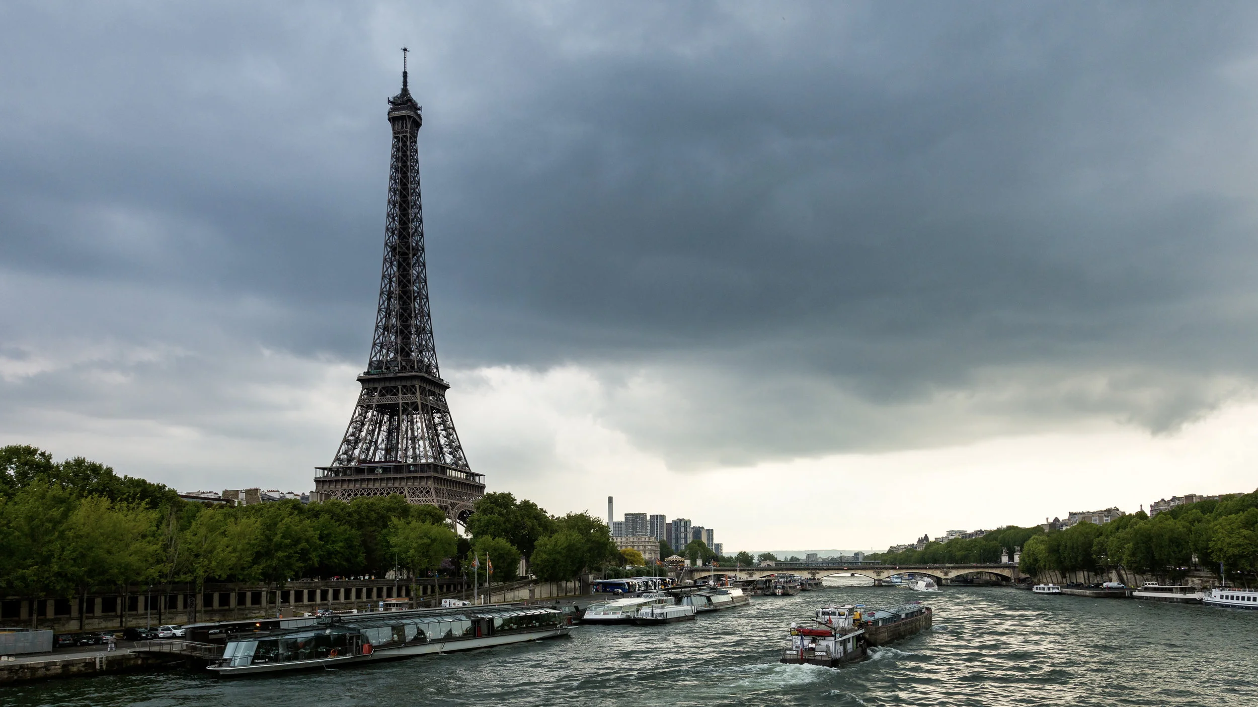 paris eiffel tower dark clouds seine river bridge bateau.jpg