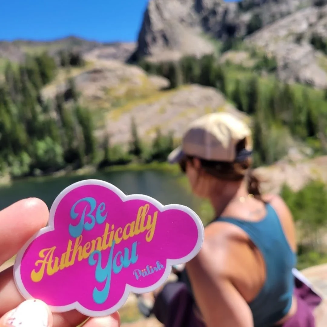Girl sitting in the mountains in utah on a hike with a be authentically you sticker .jpg