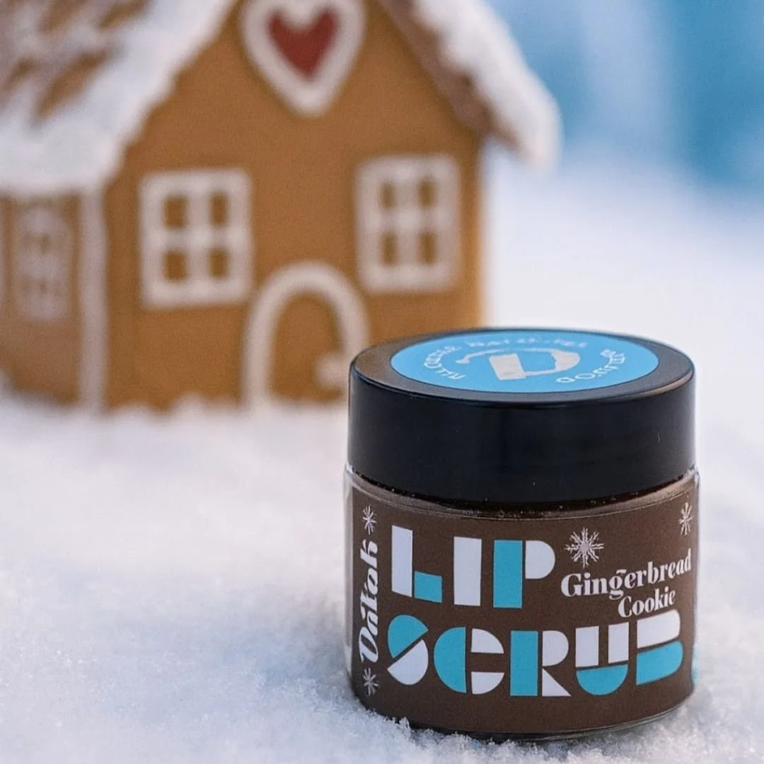 Gingerbread lip scrub in front of a cute little gingerbread house made in columbus ohio with real clean ingredients for healthy skincare.jpg