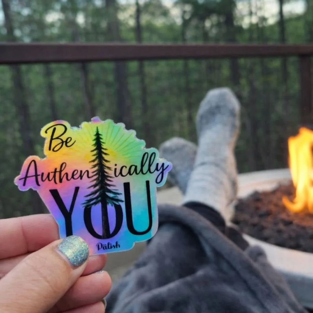 Woman holding a sticker in Cloudcroft new mexico by a fire and being her best self .jpg