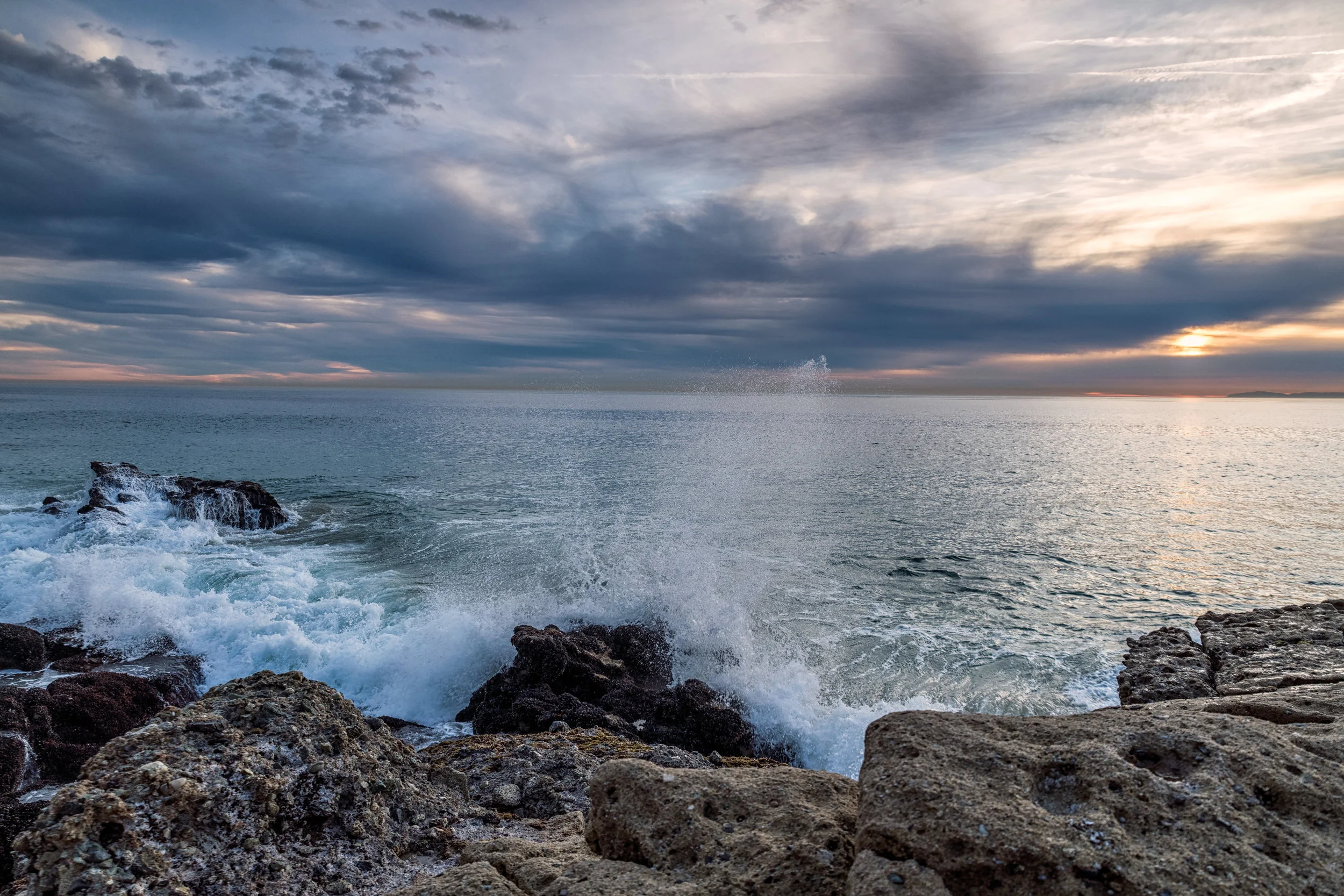A wave hits the rocks at 1000 Steps Beach.