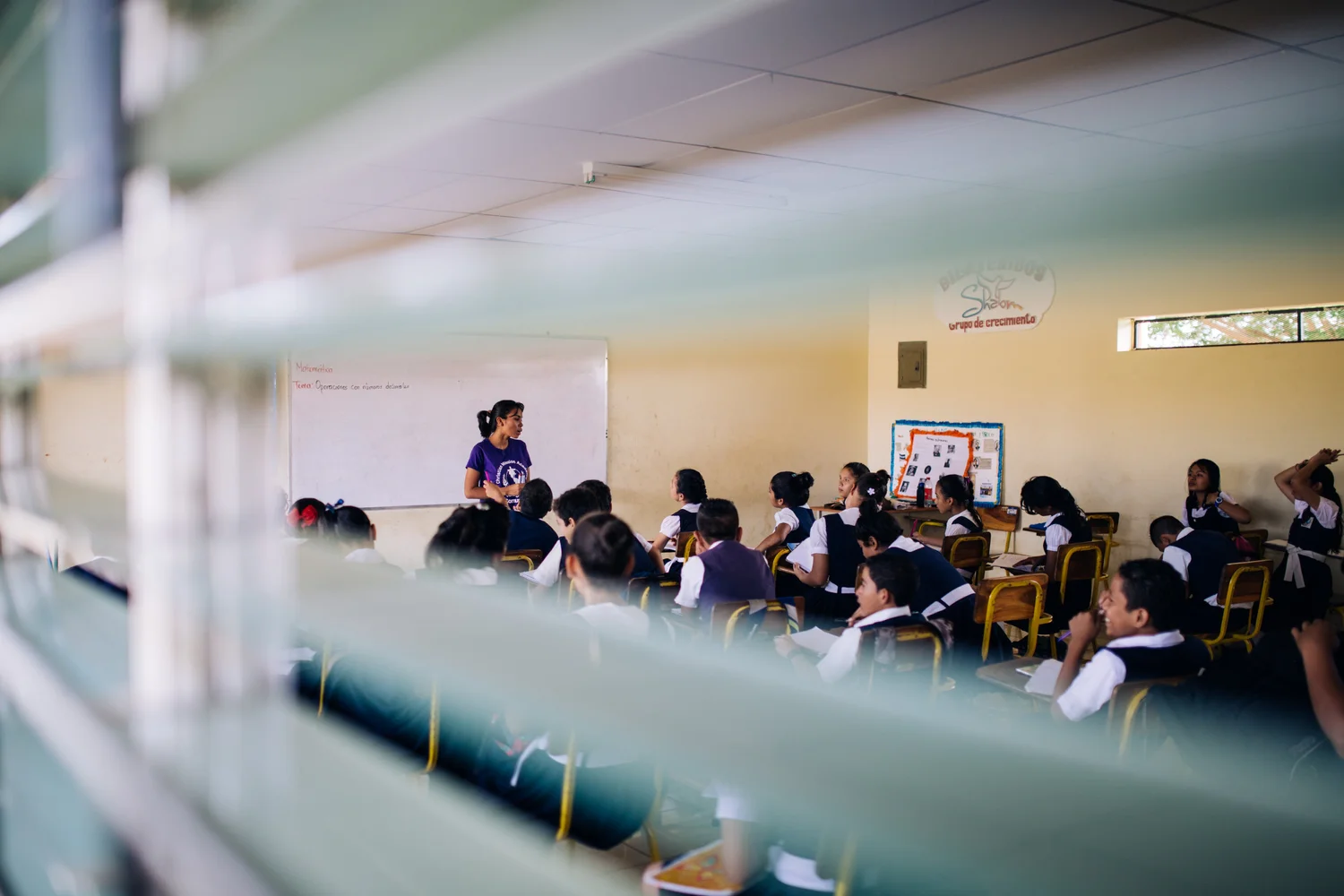 Students in a classroom looking at the camera.