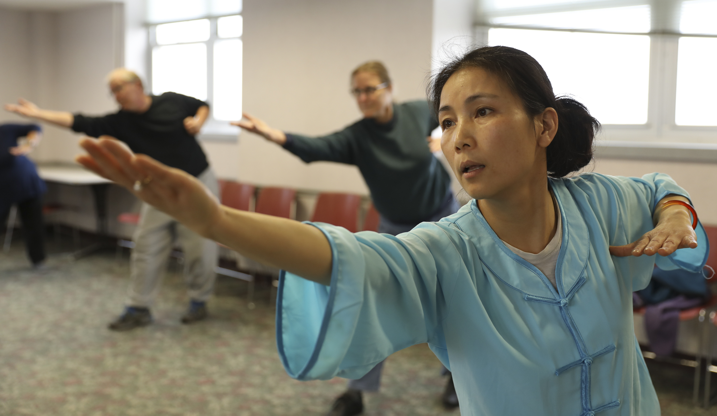  Wenfang Yang, an MU visiting scholar from Shanghai Normal University, stretches out her right arm in the Health Qi Gong class on Tuesday, March 7, 2018 at Mizzou North. MU Confucius Institute began offering this class in early January this year. 