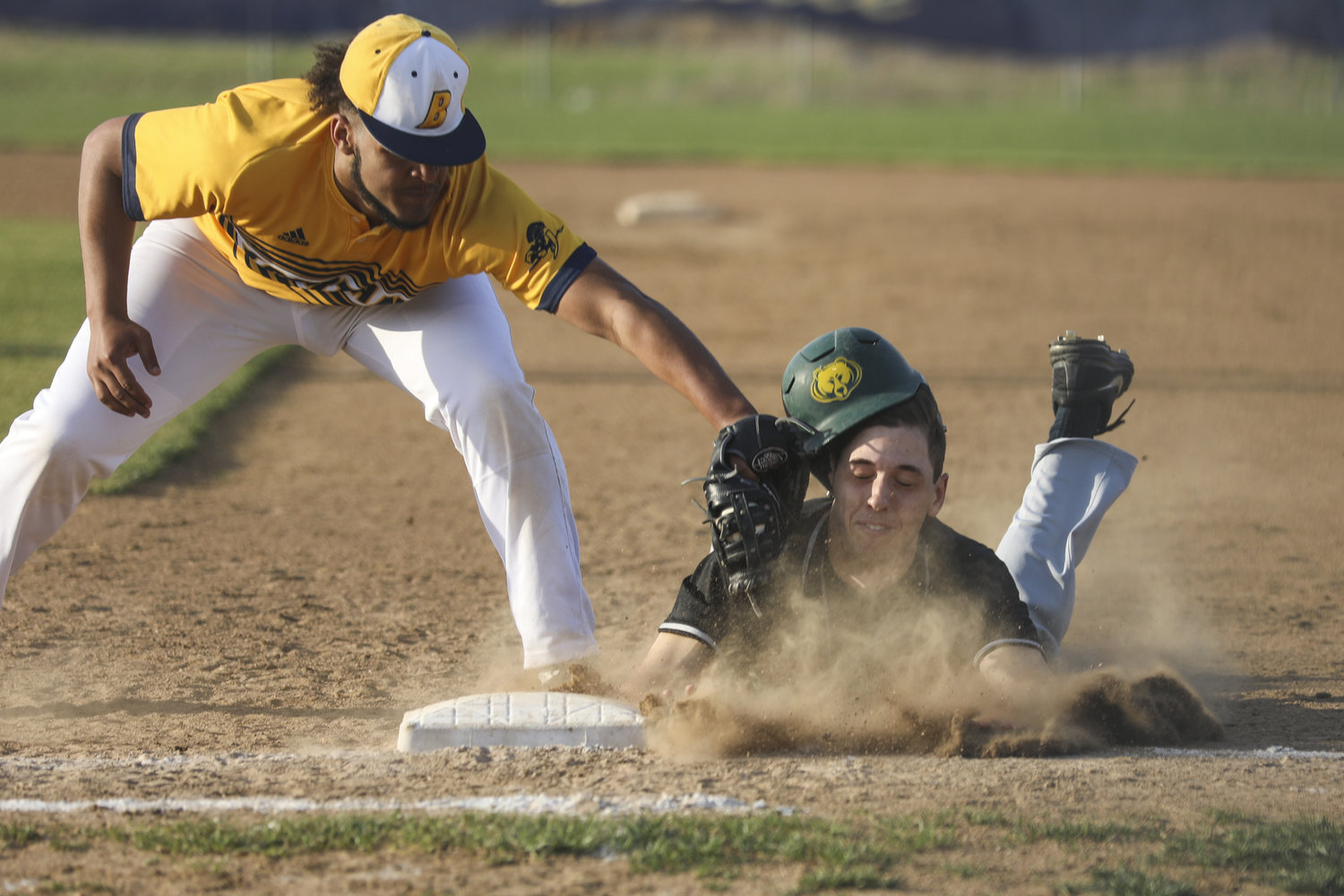  Battle’s Jarel Hyler, left, attempts to tag Rock Bridge’s Tony Pascucci during a game Tuesday at Battle High School in Columbia, Mo. the Spartans won the game 1-0 on a walk-off walk.  