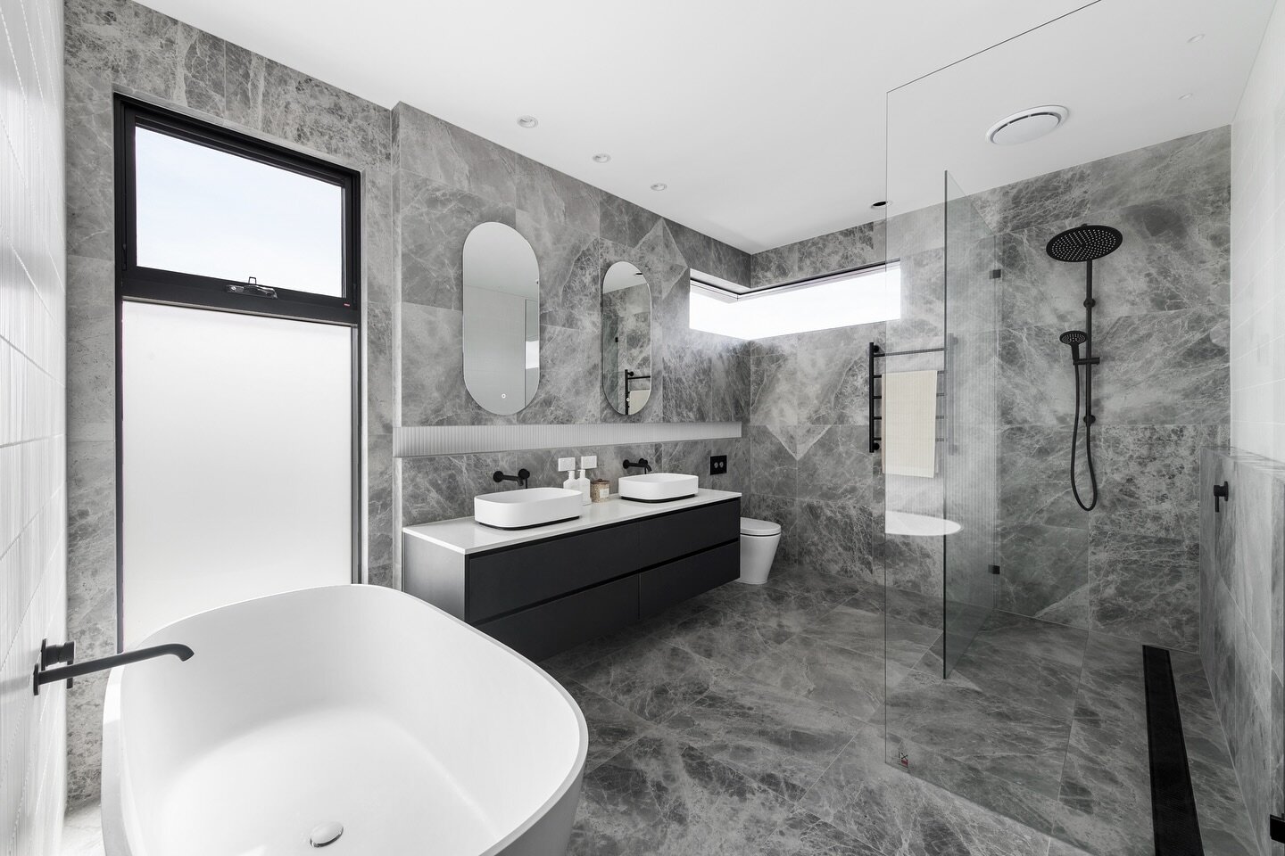 This expansive master ensuite features the finest in luxury finishes with a grand freestanding bath, matte white @abiinteriors basins with matte black tapware against 600x600mm stone look tiles throughout the space. 

Bespoke Design and Build. @minkh