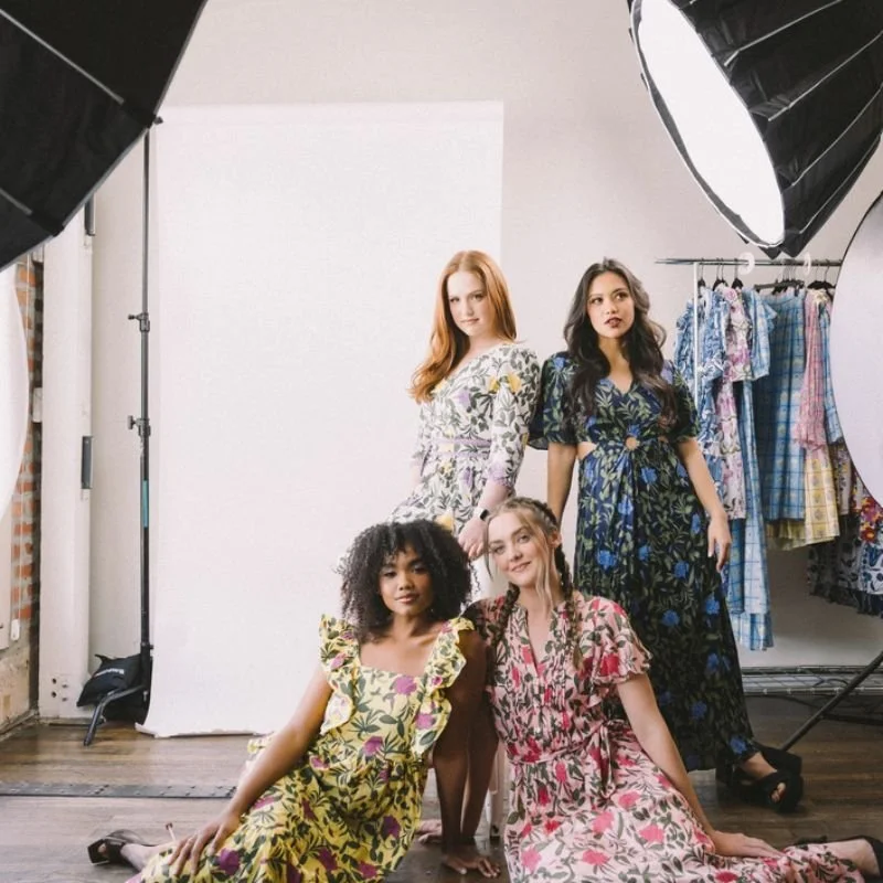 Four models wearing floral dresses at a photoshoot