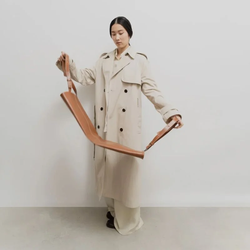 Women in trenchcoat with INTGR leather tote bag