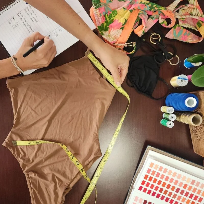 Katelyn Cunningham designing swimwewar on table with threads and books