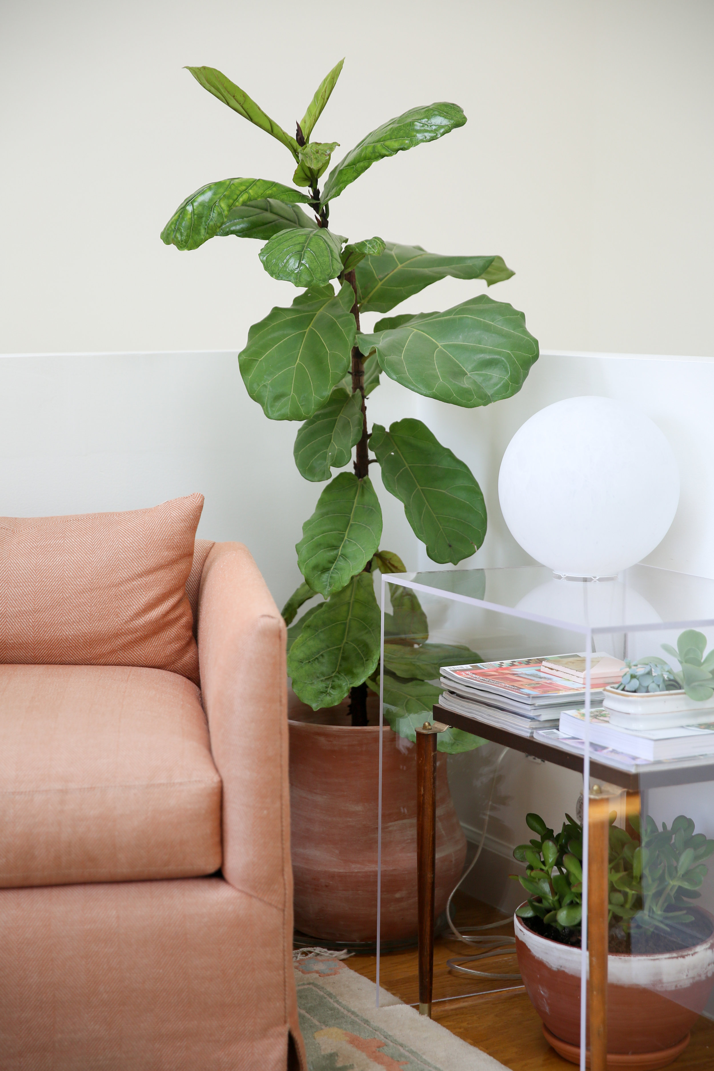 A globe table lamp found for $10 resting on a DIY acrylic table (instructions included in my latest book ).