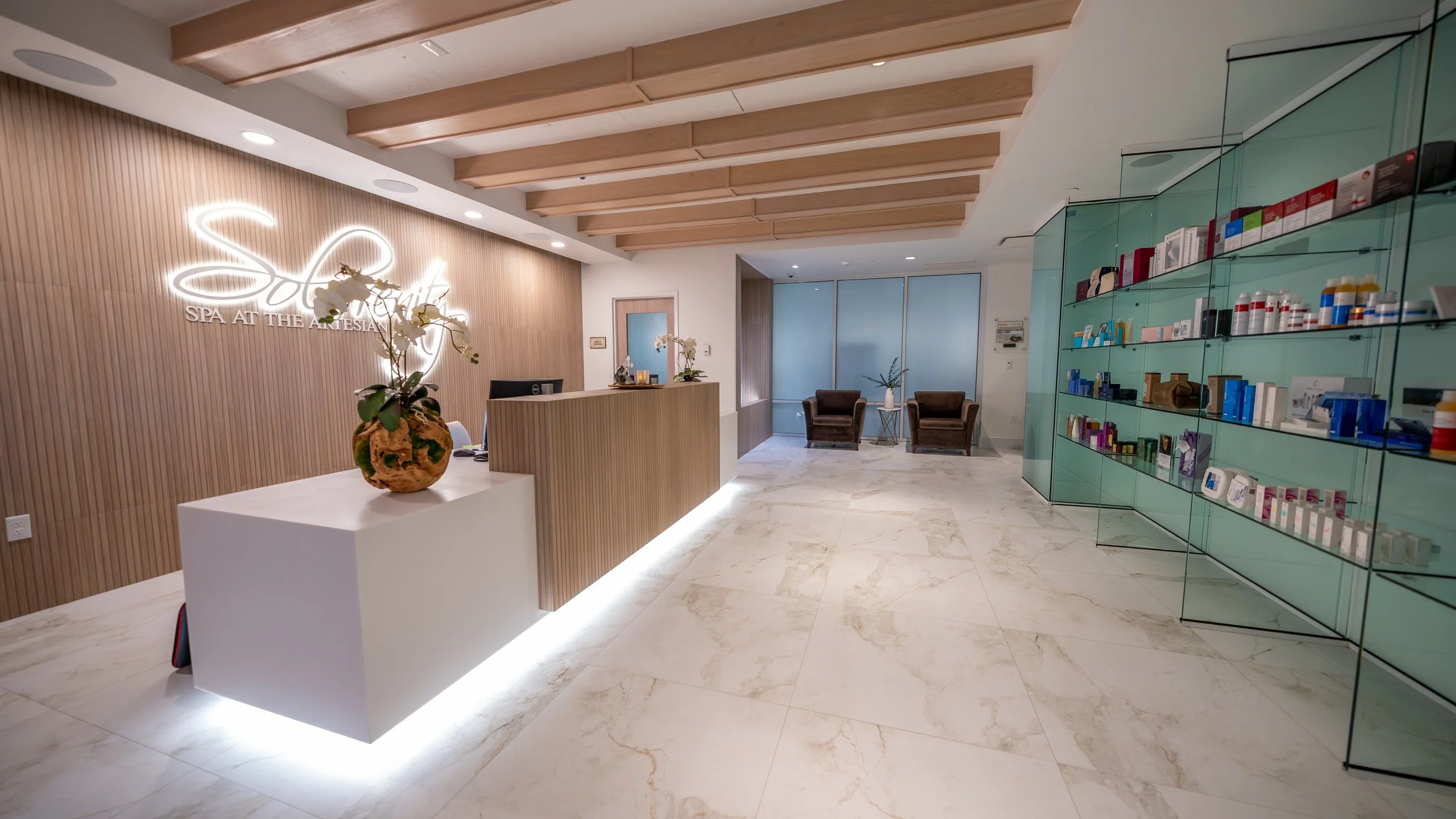 Sole’renity Spa reception area in Sulphur, Oklahoma, featuring the front desk, illuminated signage, and retail boutique