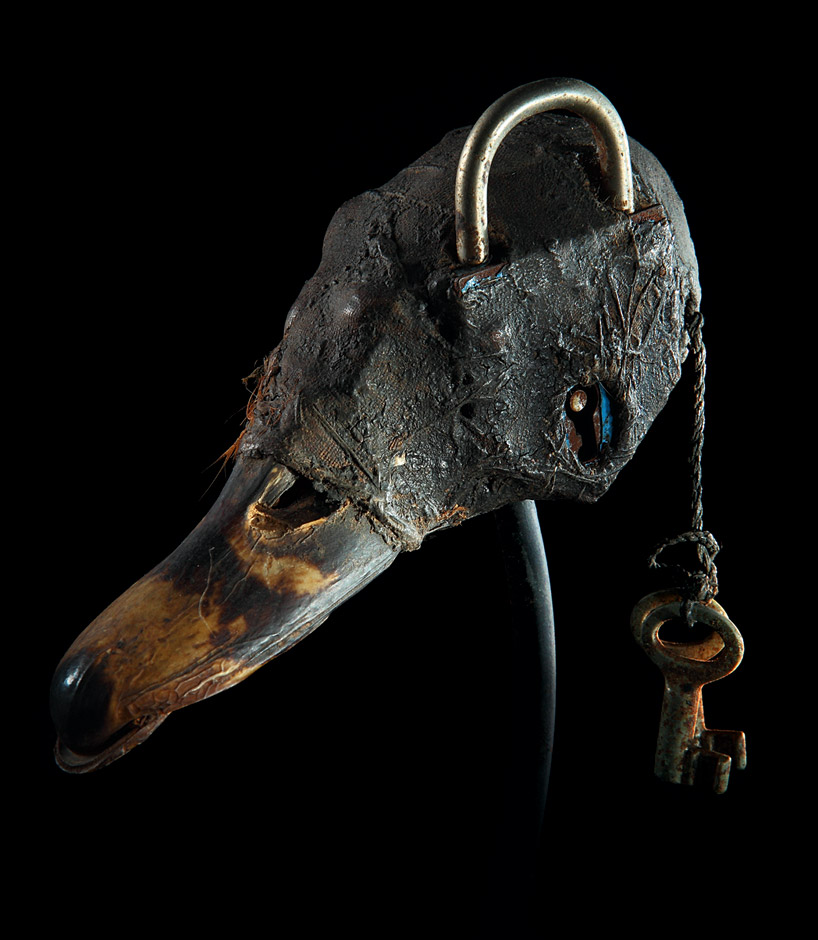 A Fon vodun (voodoo) object from Benin. Duck skull and bill, lock, keys, cloth, feather, clay, sacrificial patina.