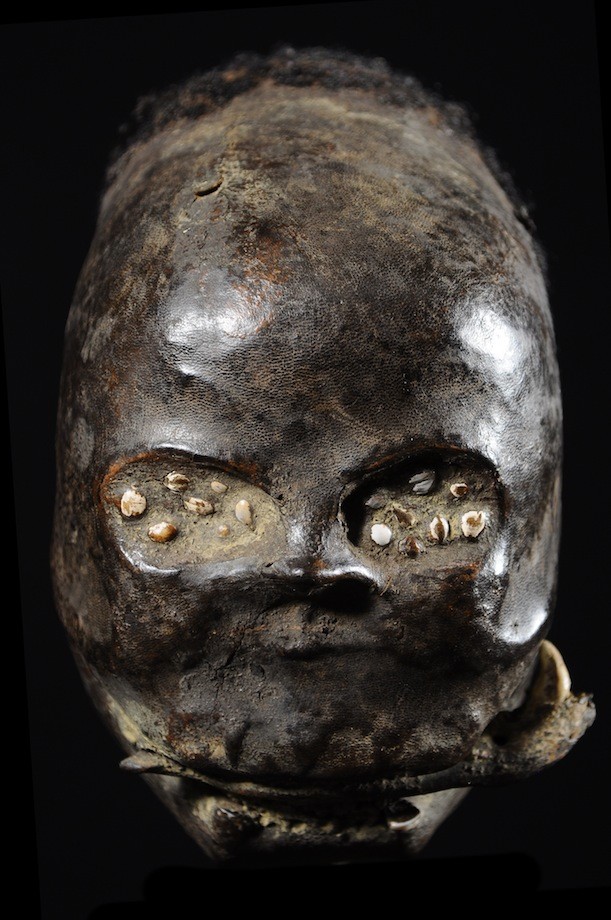 Trophy head covered in clay and human skin and hair. Collected in 1980 in southeast Nigeria. Height: 10 in (25 cm). Weight: 5.4 lbs (2,430 grams).