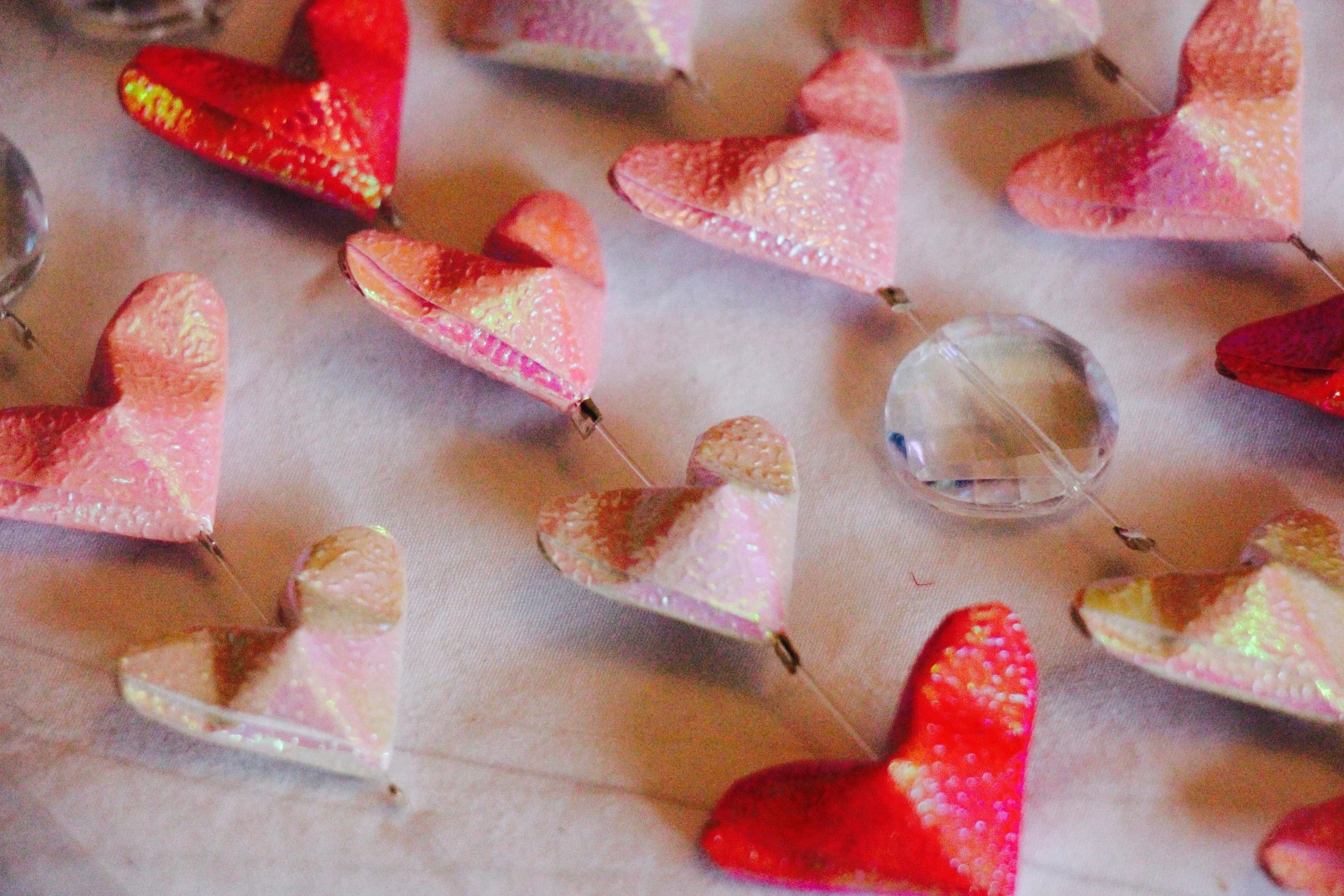 A close-up of my little origami hearts and crystal beads crimped in place on the lines.