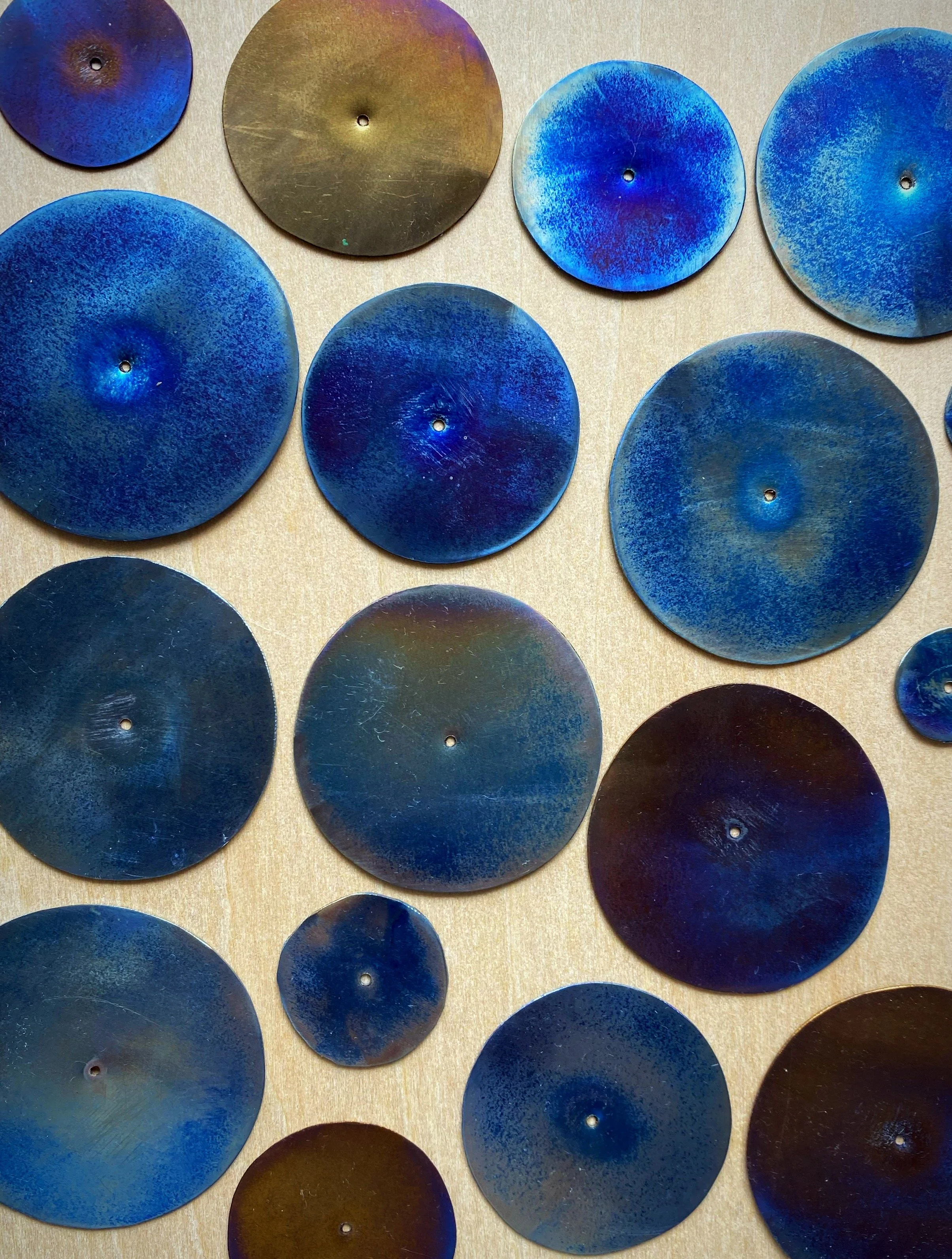 heat-coloured, hand-sawn titanium discs
