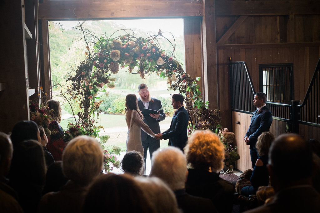 Wedding ceremony in a horse barn - Pearl Weddings & Events