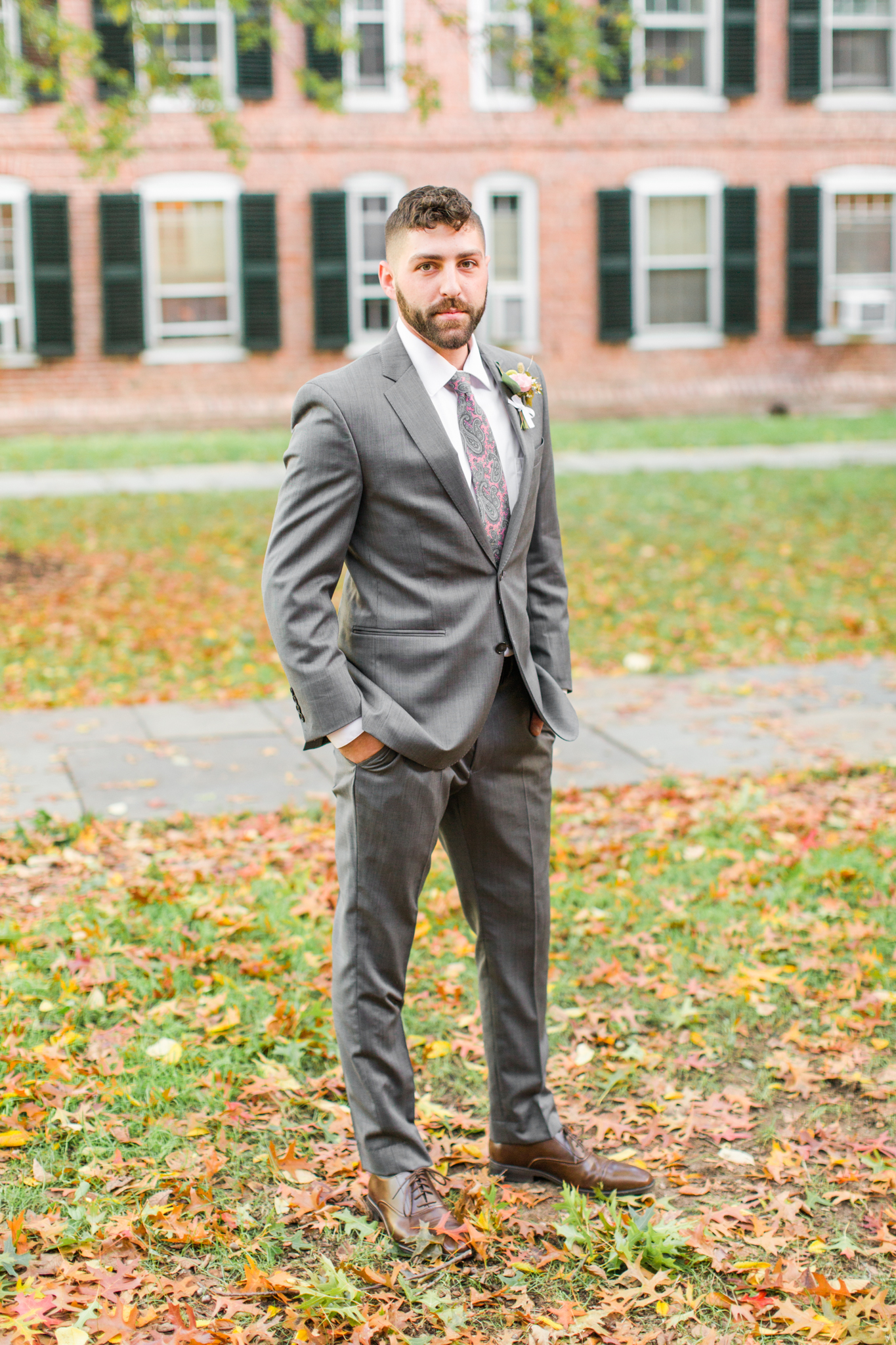 Daper groom all ready to meet his bride in his grey two piece suit and pink paisely tie- Pearl Weddings & Events