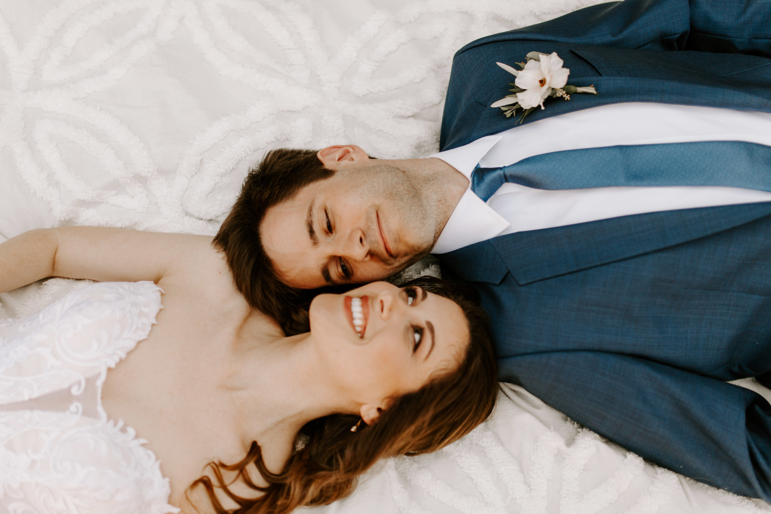 What a great couple session photo with the bride and groom lying on the ground! - Pearl Weddings & Events