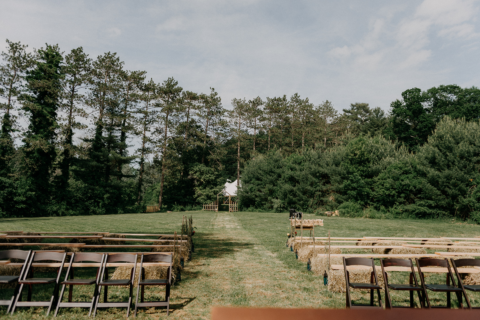 Secret garden ceremony space with benches and antique rugs - Pearl Weddings & Events