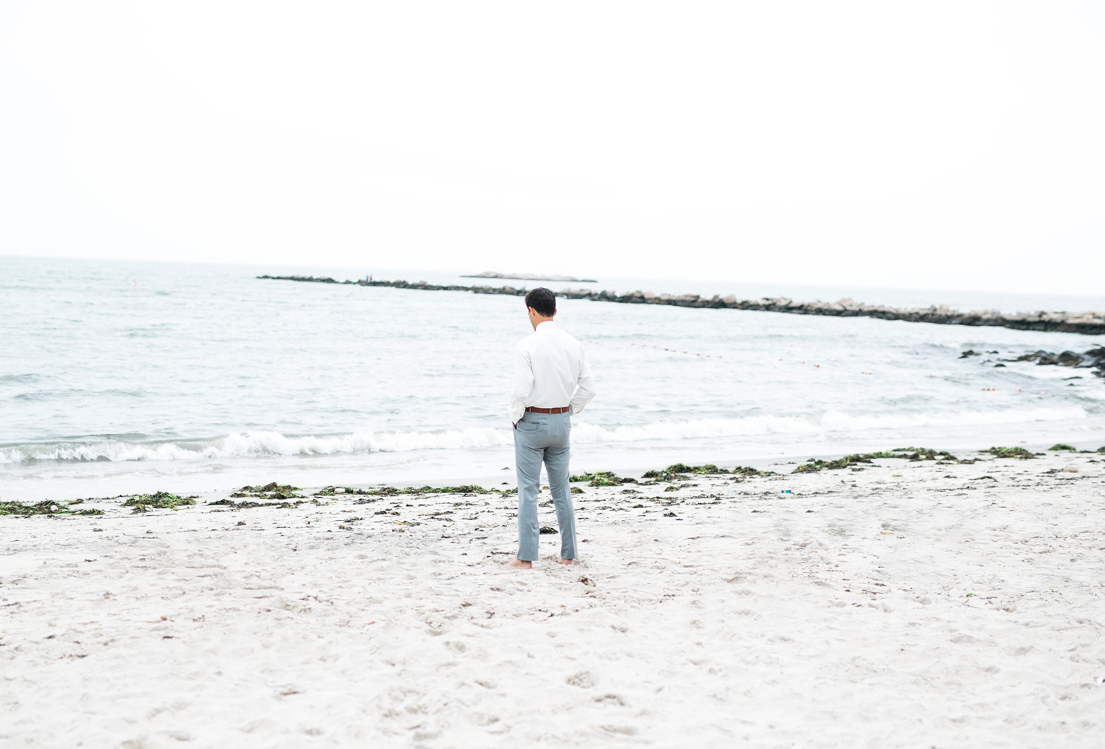 Groom awaits his bride for the first look next to the ocean - Pearl Weddings & Events