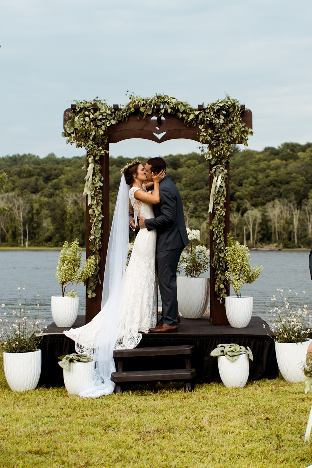 Sommar & Ben's wedding by the water in Connecticut. Wooden wedding arch way and white potted plants for the ceremony decor. - Pearl Weddings & Events