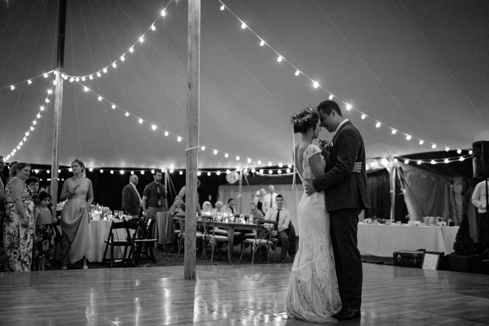 first dance under a sperry tent with cafe lighting strung and a wooden dance floor - Pearl Weddings & Events