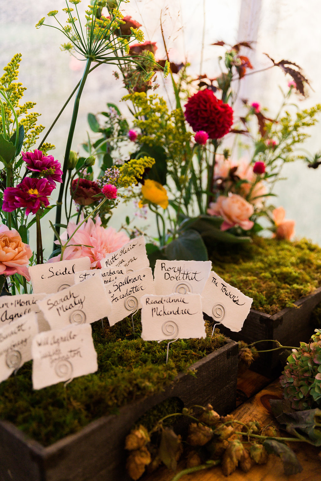 Unique name card display with greenery and organic florals! - Pearl Weddings & Events