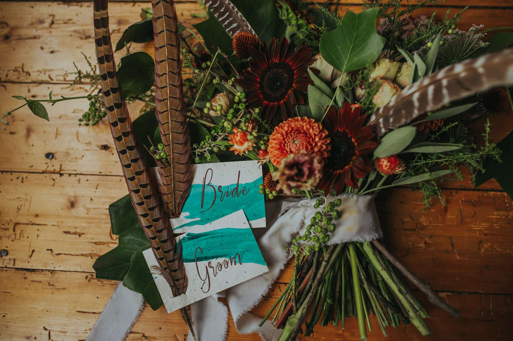 Moody bouquet with feathers and plantable name cards! - Pearl Weddings & Events