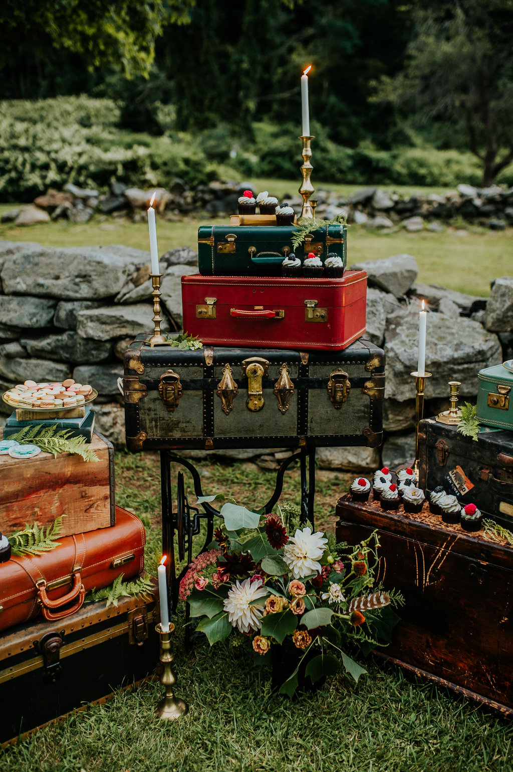 Dessert display with vintage suitcases, taper candles and floral bouquets - Pearl Weddings & Events