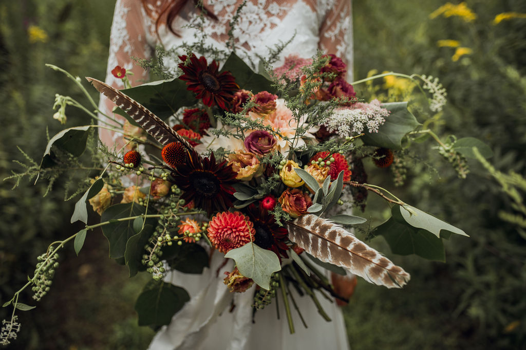 Gorgeous bouquet with deep moody tones and feather! - Pearl Weddings & Events