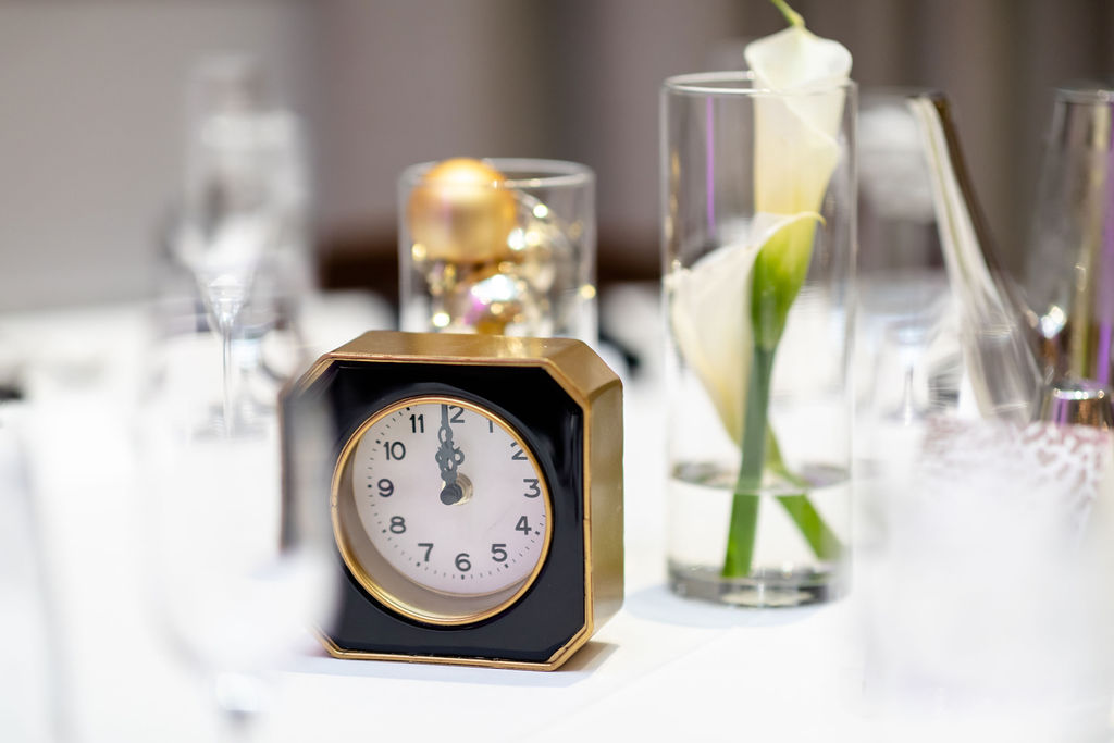 Clocks at midnight, calla lilies on the table and ornament in tall hurricane glasses - Pearl Weddings & Events