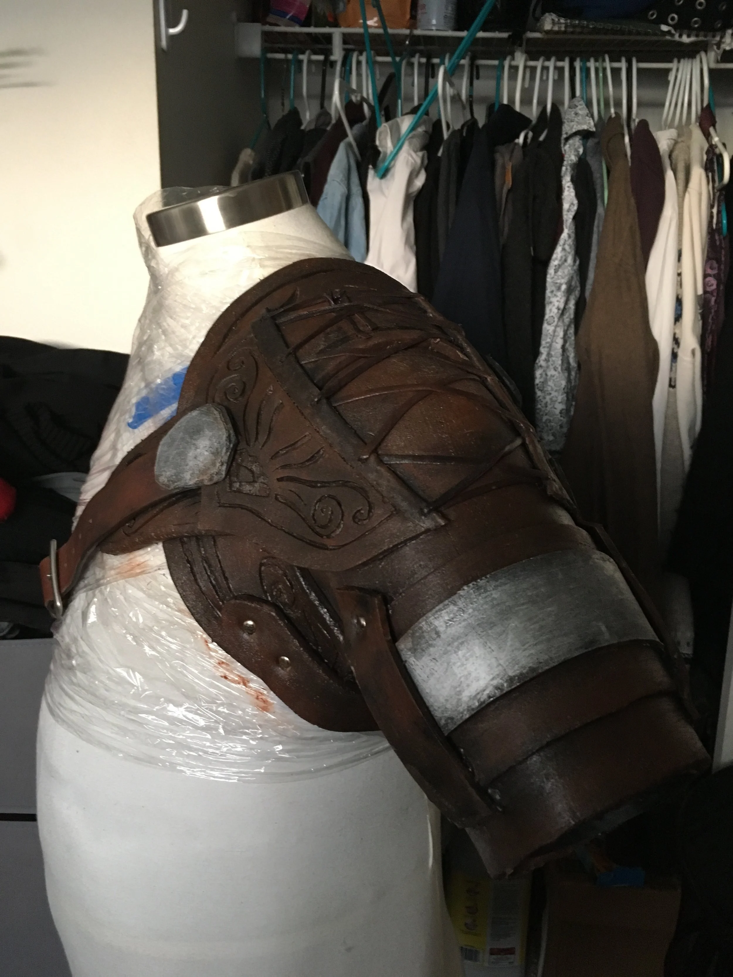  Shoulder pauldron detail. Constructed entirely of EVA foam with a muslin understructure and a found leather belt as a strap, leather cord and metal brad detailing.&nbsp; 