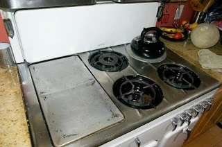 The griddle, broiler and burners of a vintage Chambers stove model B, as well as the folding cover.