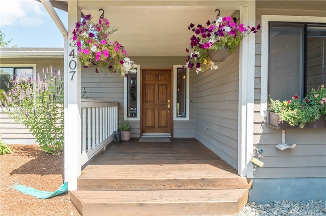 Cheerful and sheltered front porch entrance into open living and dining space.