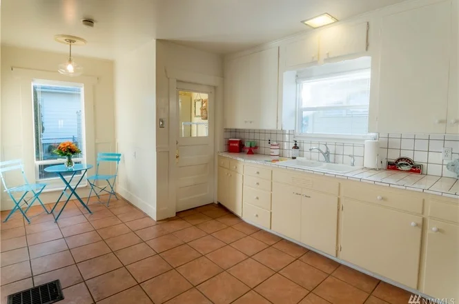 Tiled kitchen with breakfast nook, plenty of cabinets, and exit through the mud room to the backyard. 