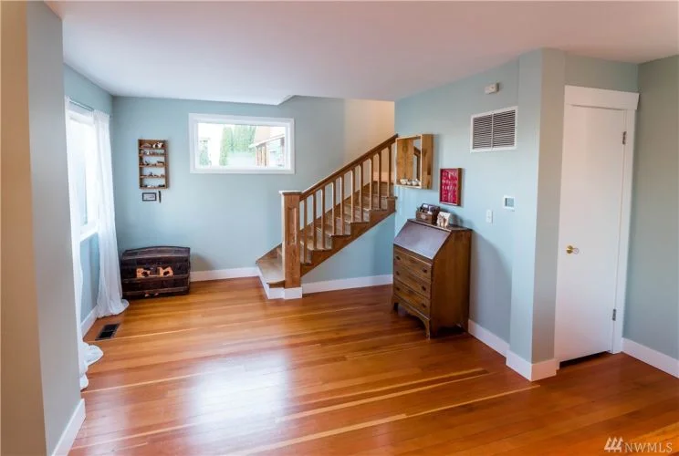 Open staircase (lovingly relieved of layers of dark paint) leads the way to upstairs bedrooms and bath. 